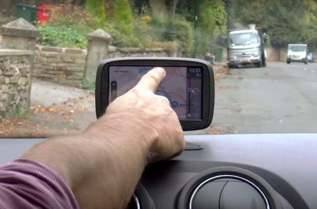 Finger pointing at sat nav in a car