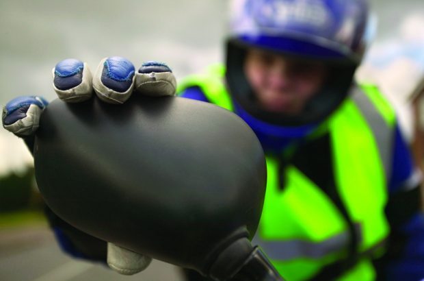 Motorcyclist adjusting wing mirror