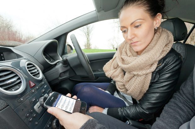 Girl in a car looking at a mobile phone