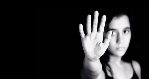 Girl in black and white holding her hand to the camera