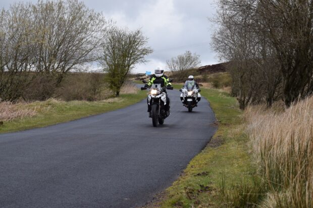 two motorcycle riding on road in the countryside