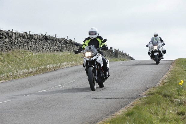 Two motorcylists riding down a country road