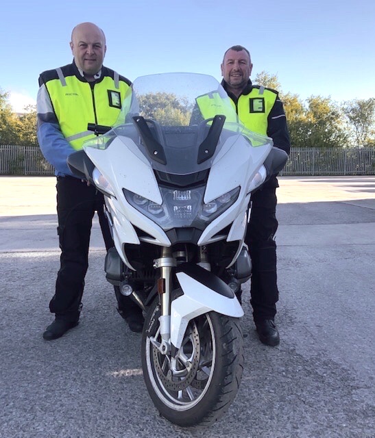 Two motorcyclists with motorbike