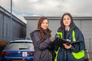 Driving examiner checking the physical provisional driving licence ahead of a test