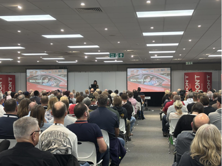 Loveday delivering a keynote speech at the ADINJC & Intelligent Instructor National Conference in September 2025